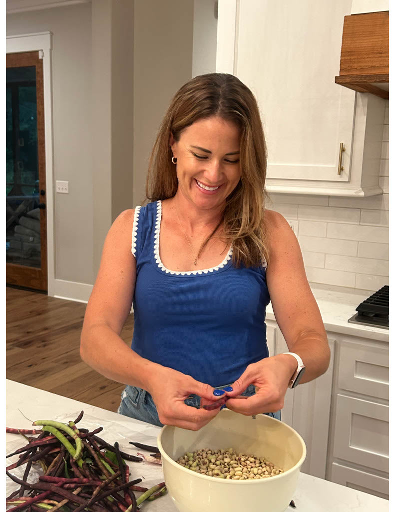 Woman in a kitchen sorting beans into a bowl